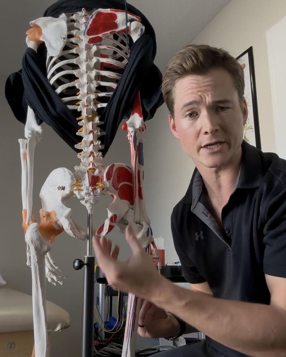Dr. Baskin pointing to an anatomy skeleton while explaining a treatment